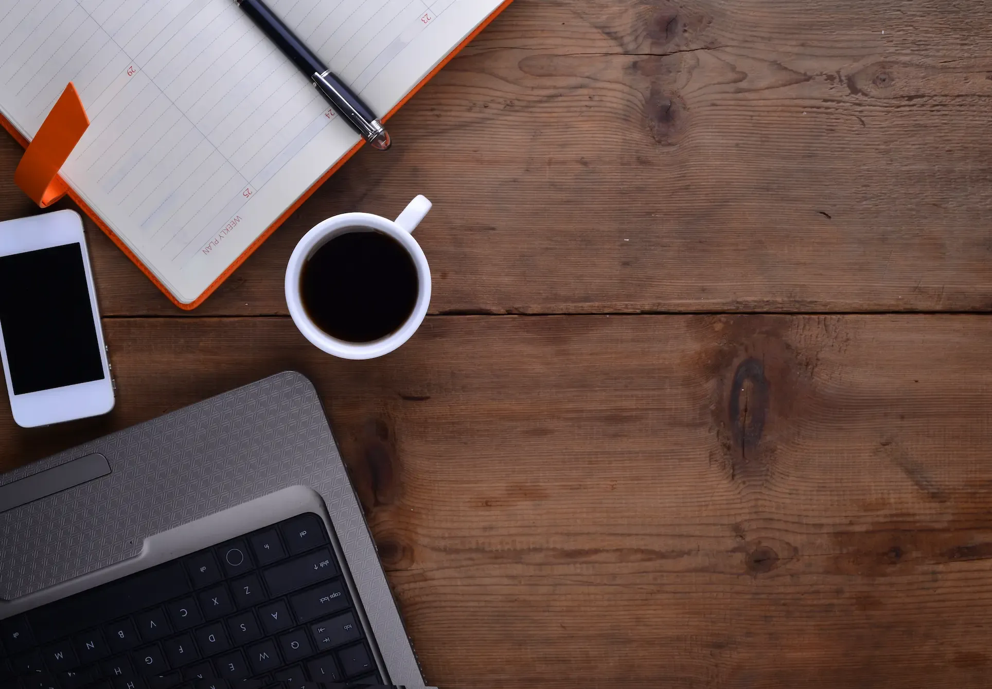 Un escritorio y una mano de una mujer con un café